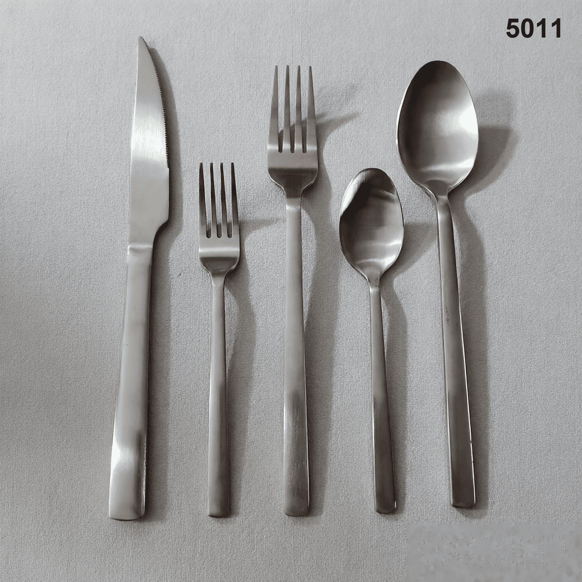 5011 clean straight-to-tapered handles with rounded ends and a restrained satin appearance 20-piece flatware set